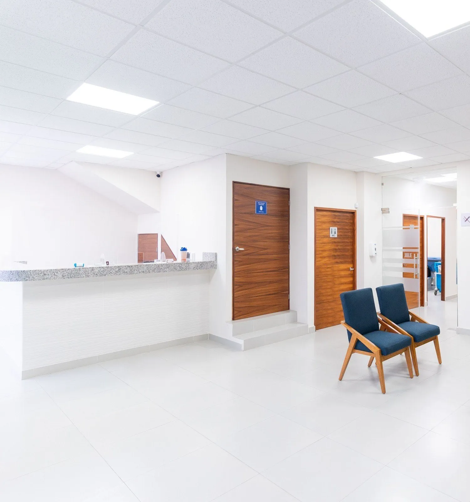 The bright waiting room with blue chairs and the reception desk